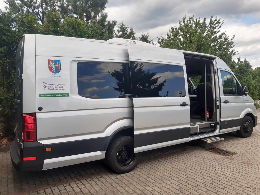 Autobus Dzienny Dom Senior+ bok pojazdu z widocznym oznakowaniem dofinsowanie z PFRON, herb powiatu chrzanowskiego