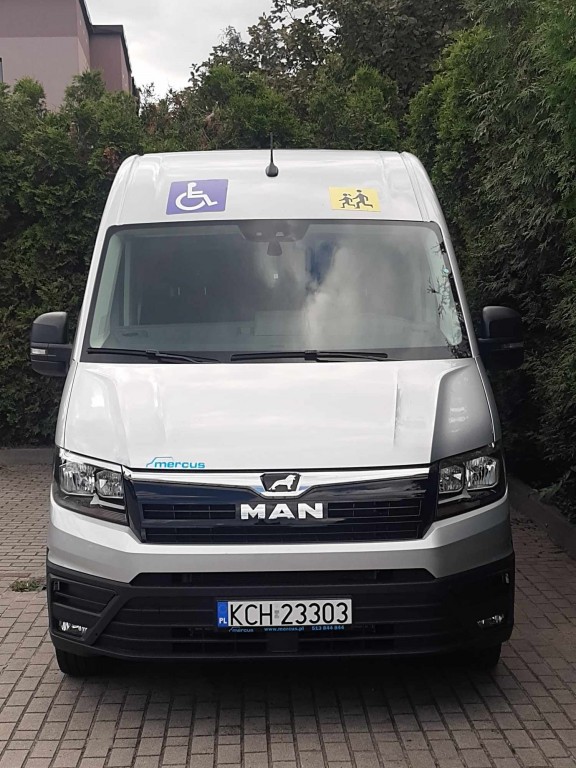 Autobus Dzienny Dom Senior+ z oznakowaniem przednim pojazd dla osób z niepełnosprawnościami oraz symbolem pojazd przewożacy dzieci