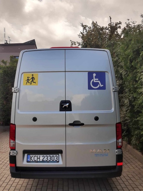 Autobus Dzienny Dom Senio+ z oznakowaniem tył pojazdu dla osób z niepełnosprawnościami oraz symbolem pojazd przewożący dzieci